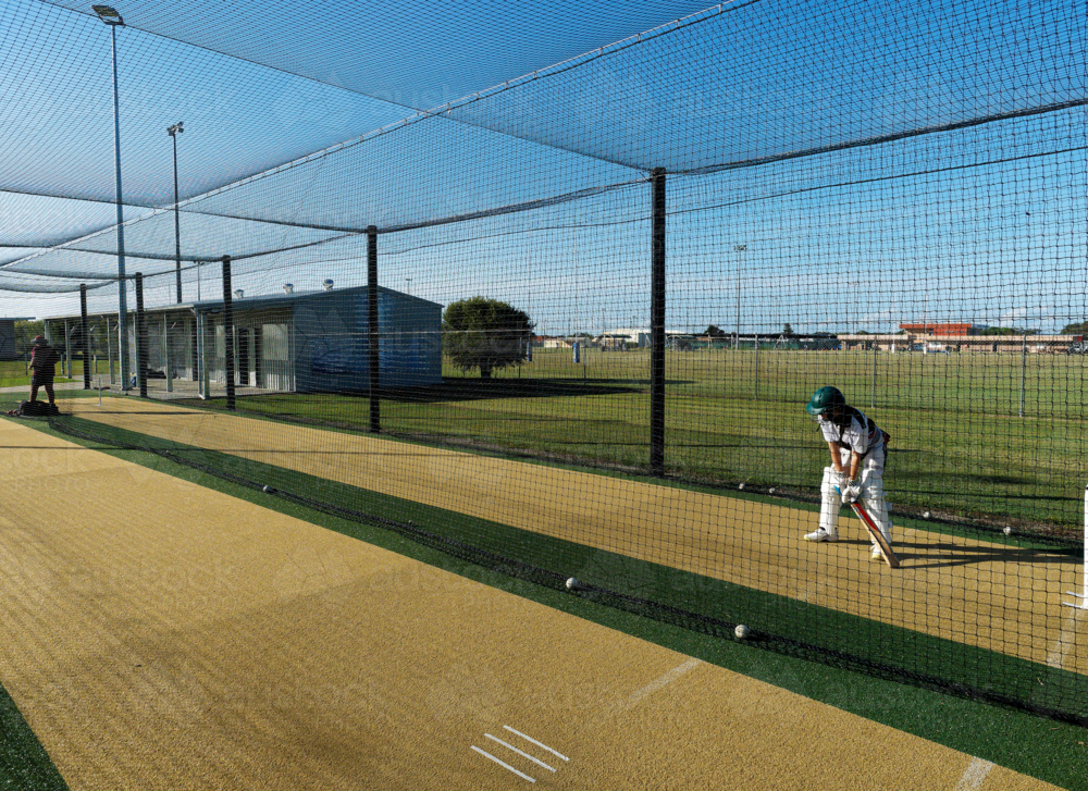 Junior cricketer standing ready during outdoor practice session - Australian Stock Image