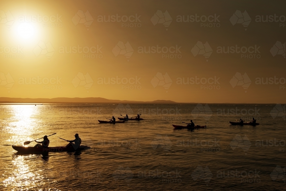 Kayakers at sunset paddling at 1770 - Australian Stock Image