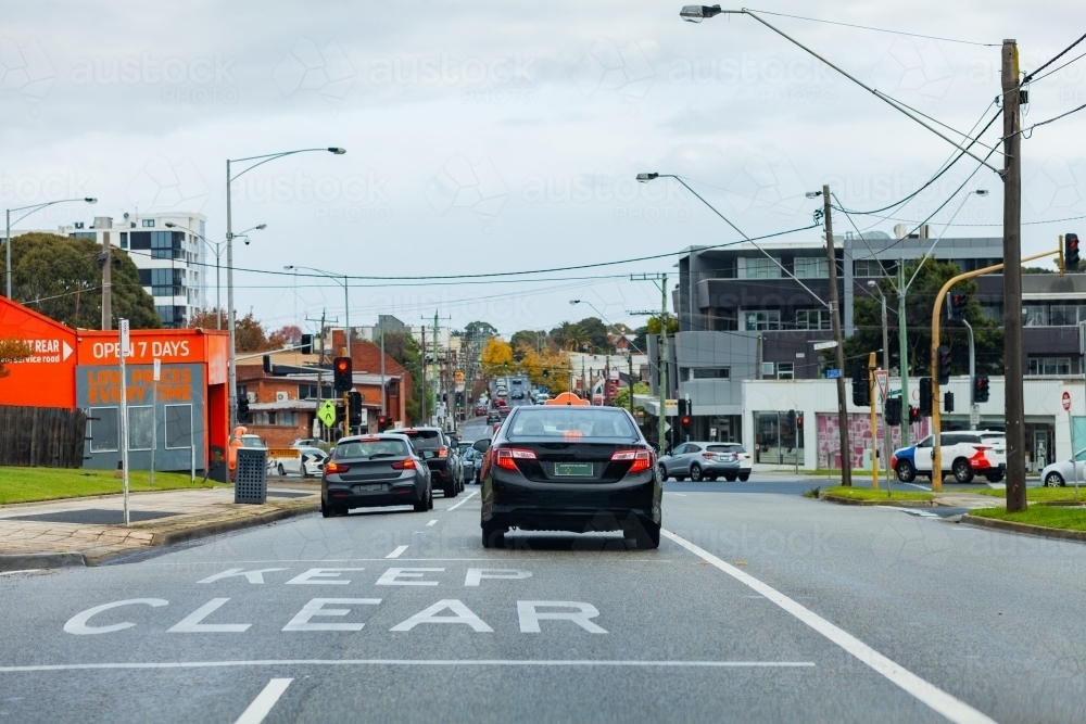Image of Keep clear sign on road with traffic stopped at lights in ...