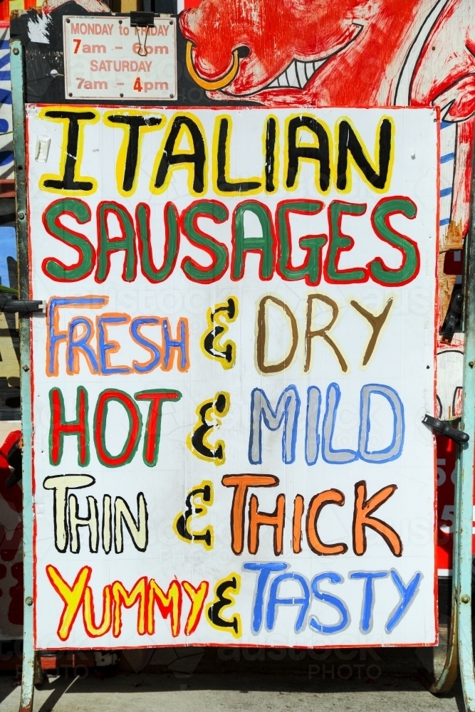 Kerbside butcher signs advertise assorted Italian sausages for sale - Australian Stock Image