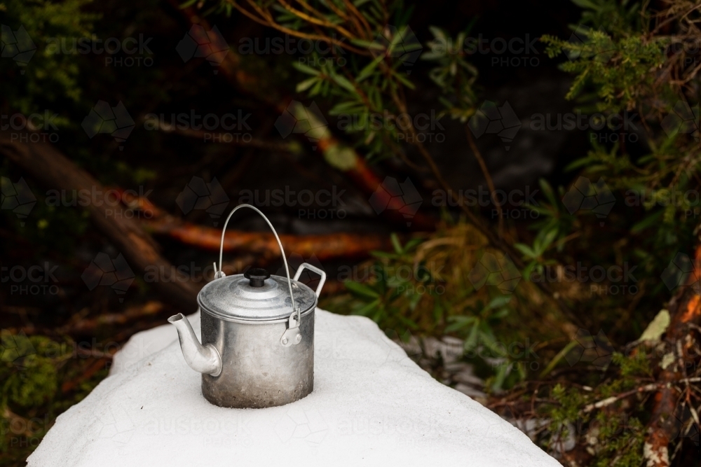 Kettle on a snowy mound in a forest - Australian Stock Image