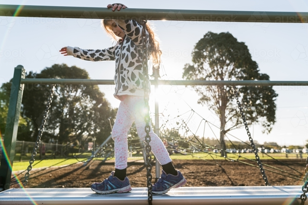 Kid playing at the park outdoors balancing - Australian Stock Image
