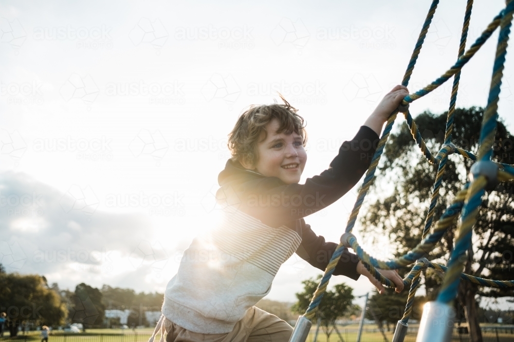 Kid playing at the park outdoors climbing - Australian Stock Image