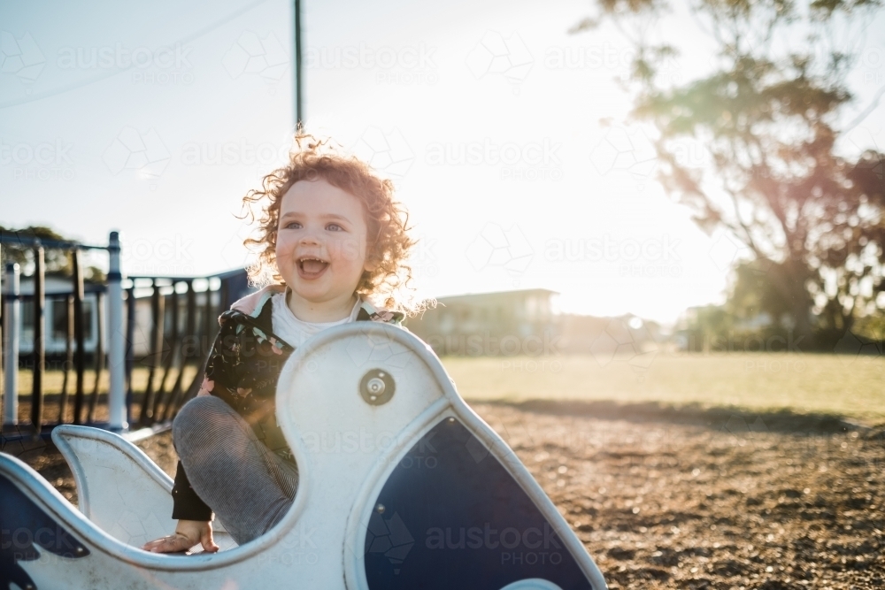 Kid playing at the park outdoors in winter sunshine - Australian Stock Image