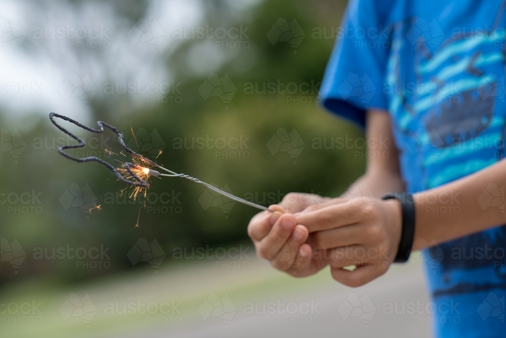 Kid playing with sparklers on New Years Eve - Australian Stock Image