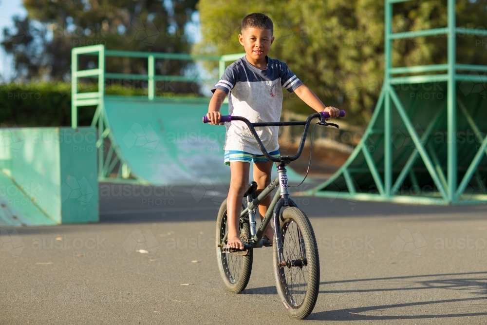 Kid riding a bike at a skate park - Australian Stock Image