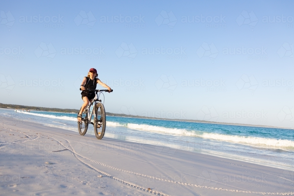 Kid riding bike along the beach - Australian Stock Image