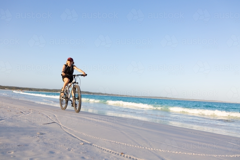 Kid riding bike along the beach - Australian Stock Image