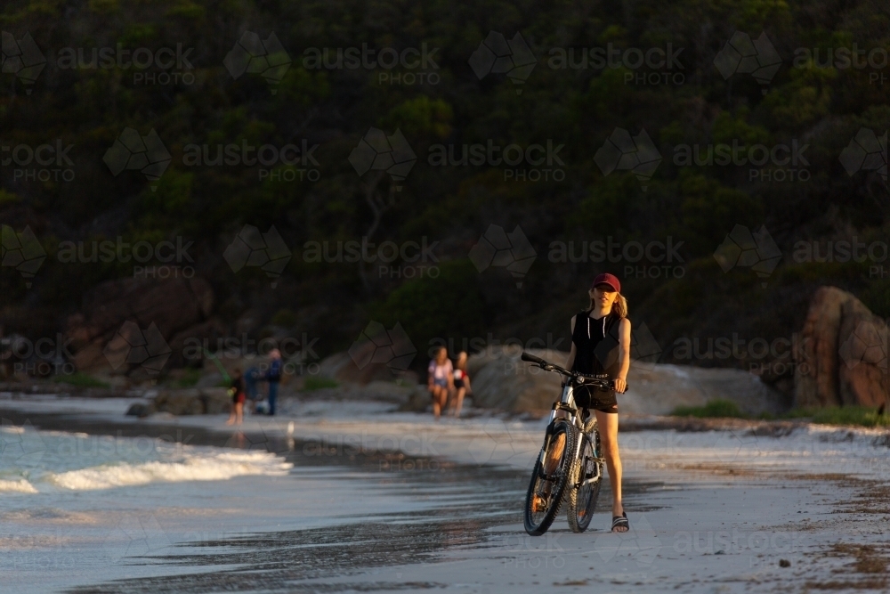 Kid riding bike on beach - Australian Stock Image