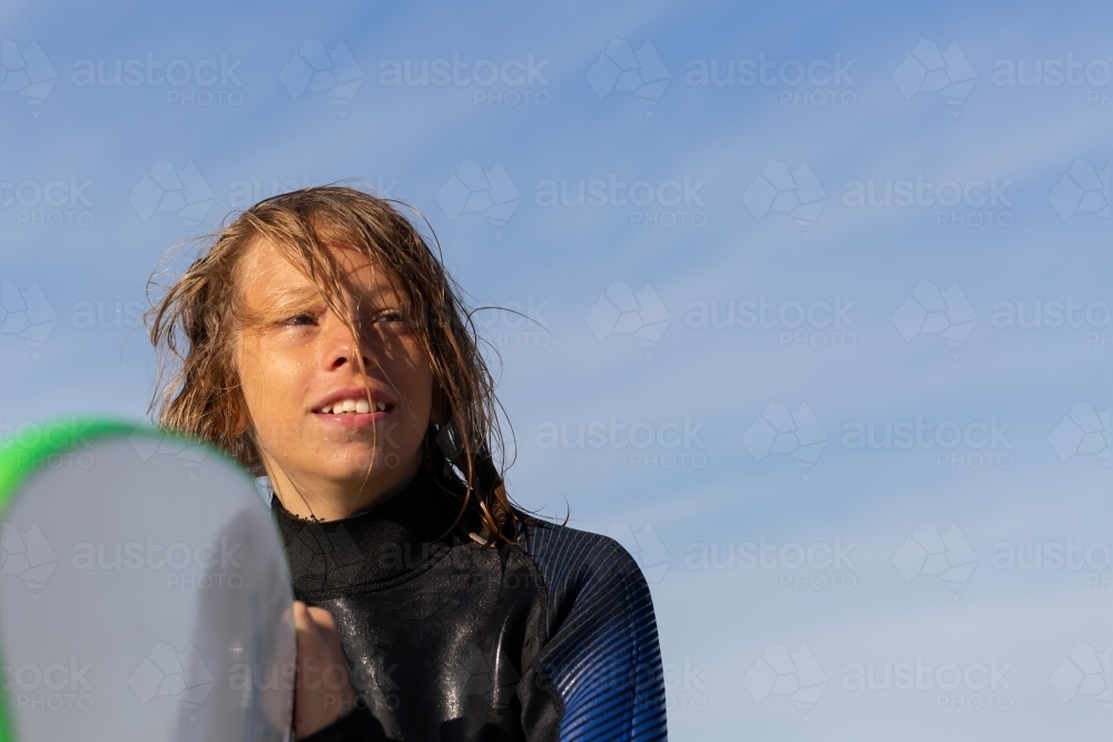Kid with messy hair with surfboard - Australian Stock Image