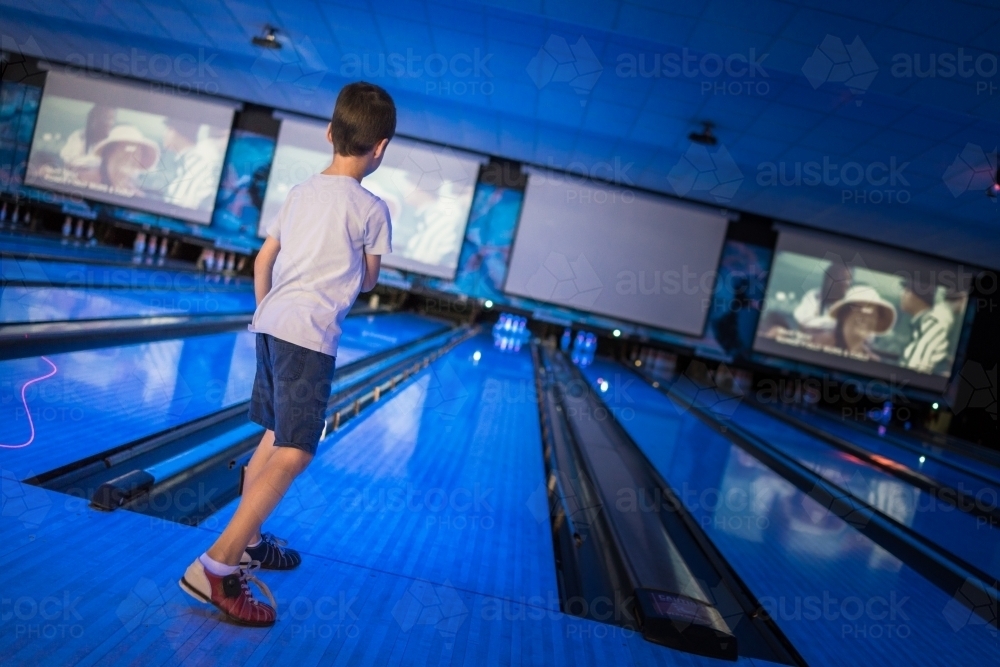 Kids 10 pin bowling under blue lights - Australian Stock Image