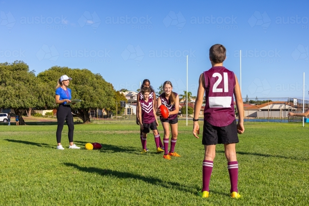 kids and their coach practising football skills - Australian Stock Image