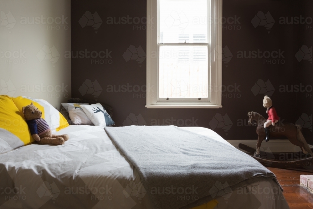 Kids bedroom with soft toys and a dark painted wall - Australian Stock Image