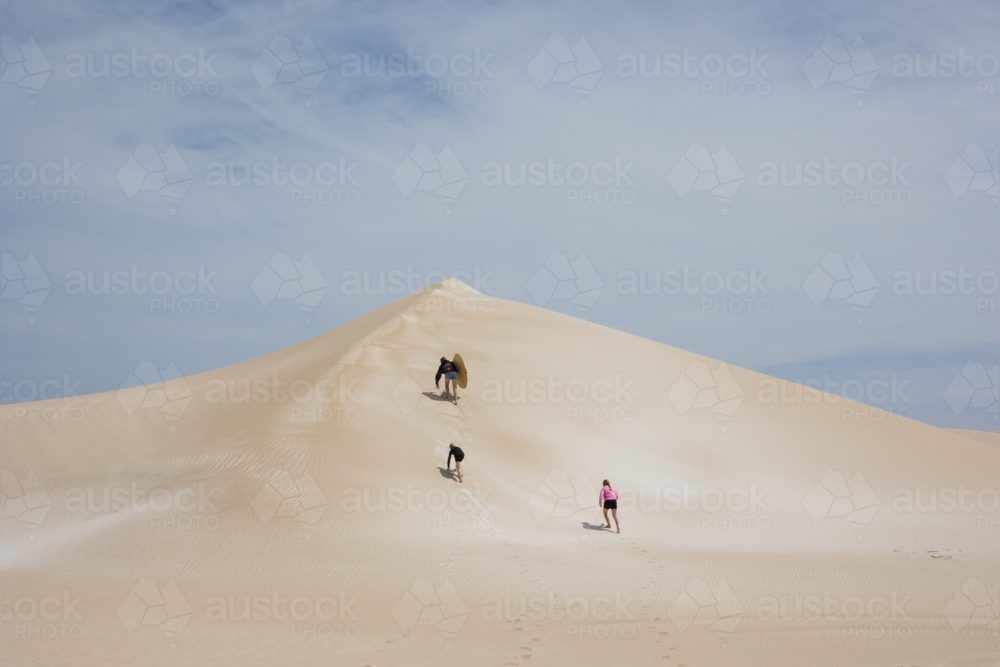 Kids climbing to top of sand dune in remote Australia - Australian Stock Image