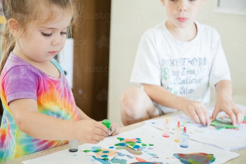 Kids doing colourful Christmas craft with food colouring paint - Australian Stock Image