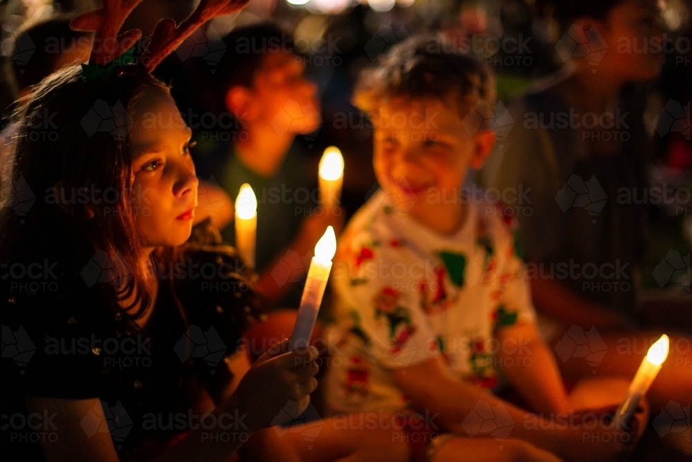 kids holding candles at carols by candlelight at night - Australian Stock Image