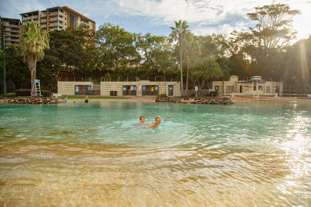 Kids swimming at the Settlement Cove Lagoon swimming pool in Redcliffe, Queensland Australia - Australian Stock Image