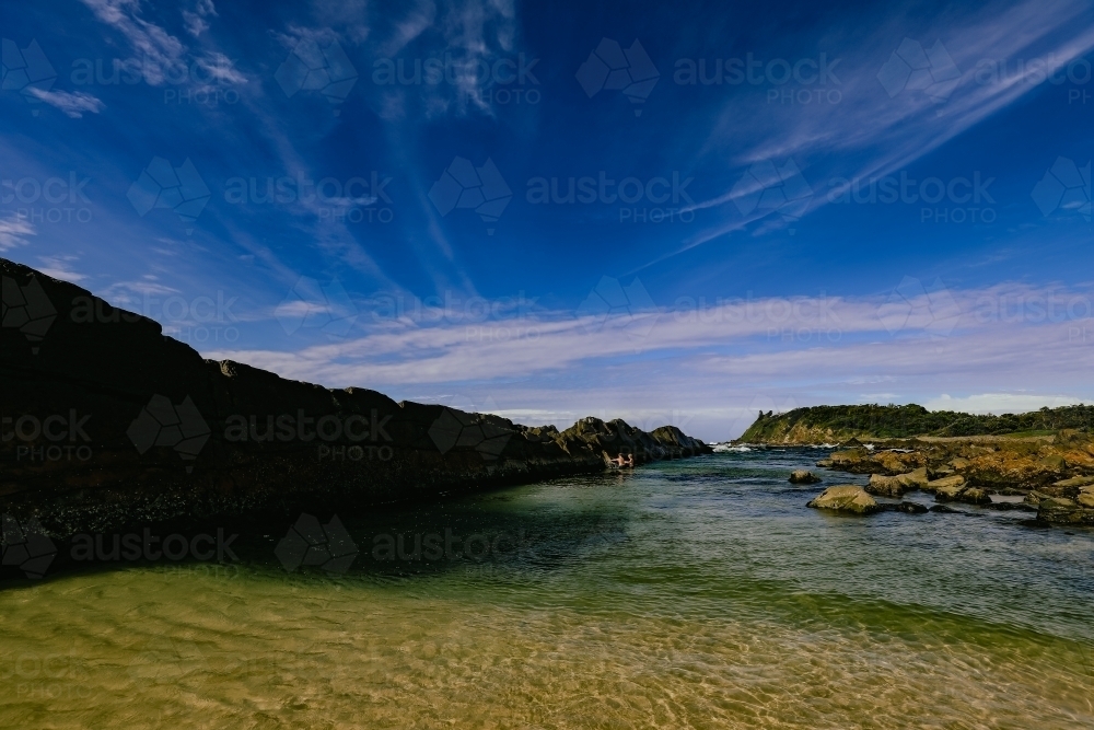 Kids swimming at The Tanks tourist attraction natural rock pool - Australian Stock Image