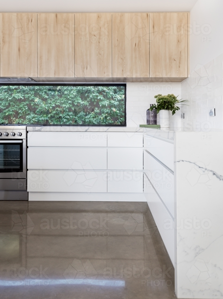 Kitchen details of concrete floor and oversized soft close drawers - Australian Stock Image