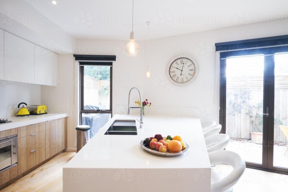 Image of Kitchen island bench with pendant lighting in contemporary