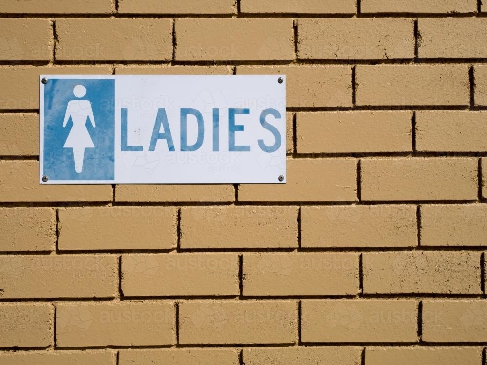 "LADIES" sign on a light coloured brick wall - Australian Stock Image