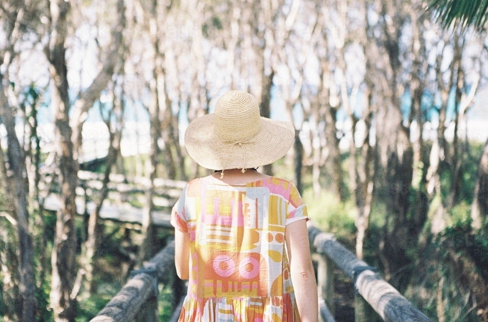 Lady in pastel walking toward the beach - Australian Stock Image