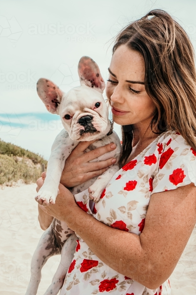 Lady looks at her little puppy. - Australian Stock Image