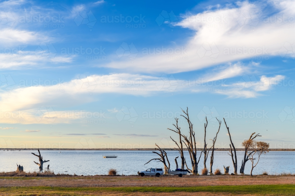 Lake Bonney with dead tree stumps in water at sunset time, Barmera, South Australia - Australian Stock Image