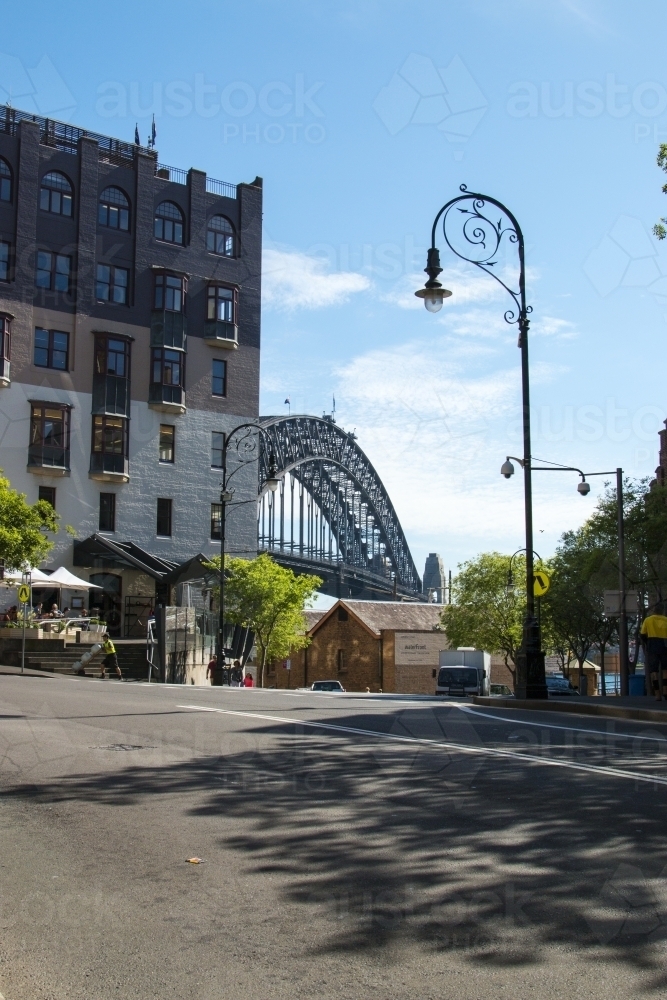 Lamp post on Sydney street with old buildings and bridge in the background - Australian Stock Image