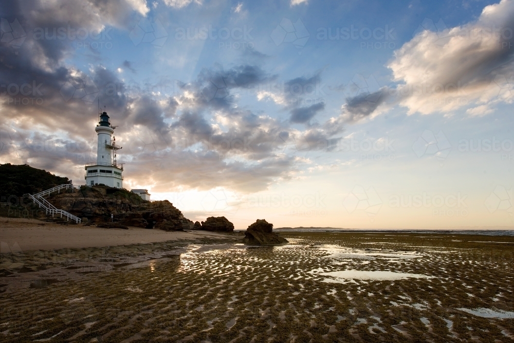 Landscape of lighthouse and beach at low tide - Australian Stock Image