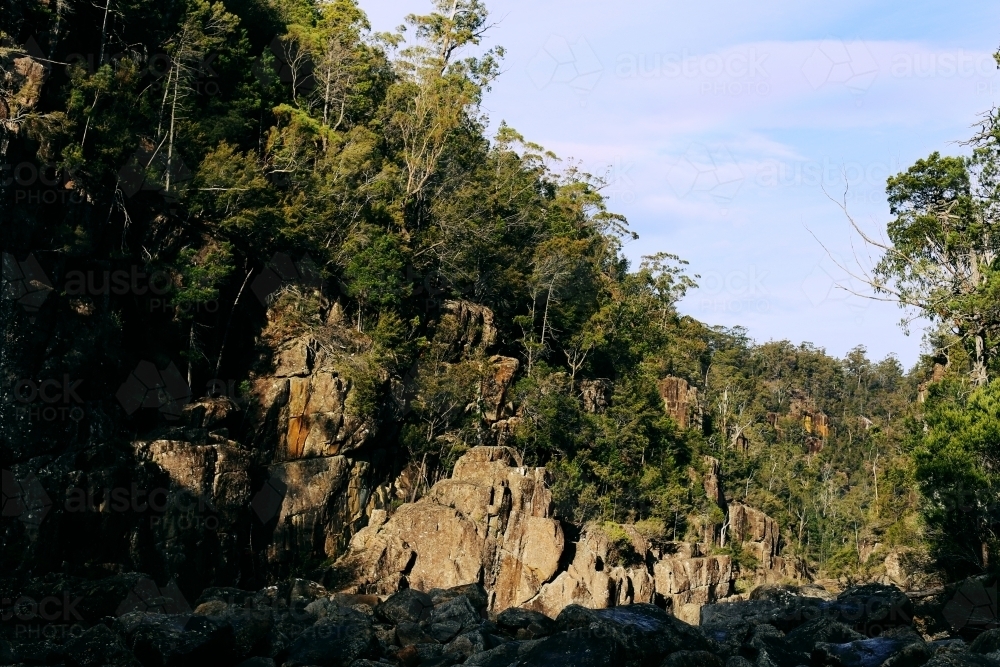 Landscape of rock face with trees in bushland - Australian Stock Image