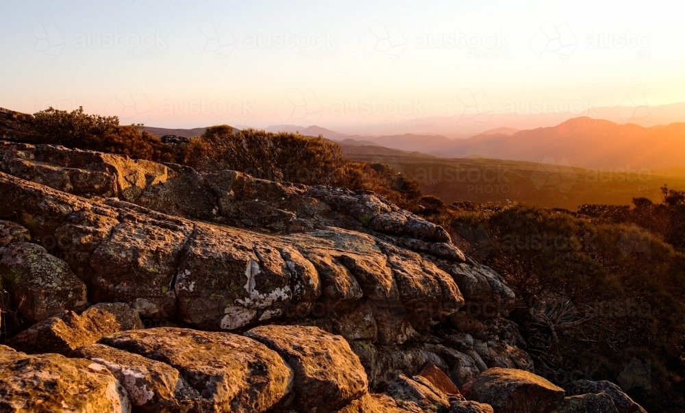 Landscape of rocks and mountain range at sunset - Australian Stock Image