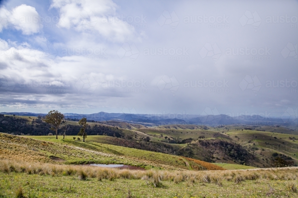 Landscape of rolling hills and distant rain - Australian Stock Image