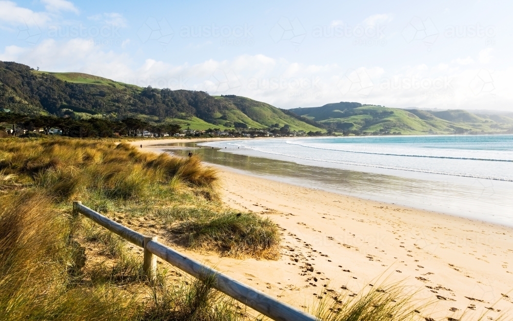 Landscape of sweeping beach with hills in background - Australian Stock Image