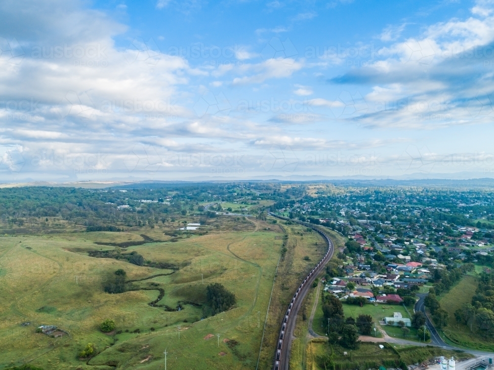 Landscape view of edge of town of Singleton with coal train on railway - Australian Stock Image