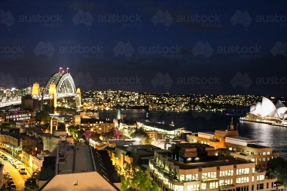 Landscape view of Sydney Harbour Bridge and Sydney Opera House with lights at night - Australian Stock Image