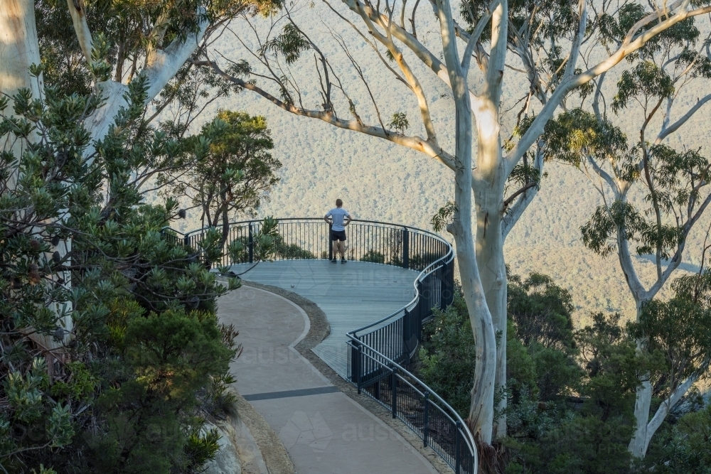 Landscaped lookout in bushland with distant person and view into valley - Australian Stock Image
