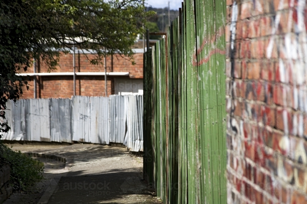 Laneway with brick and corrugated iron fence - Australian Stock Image