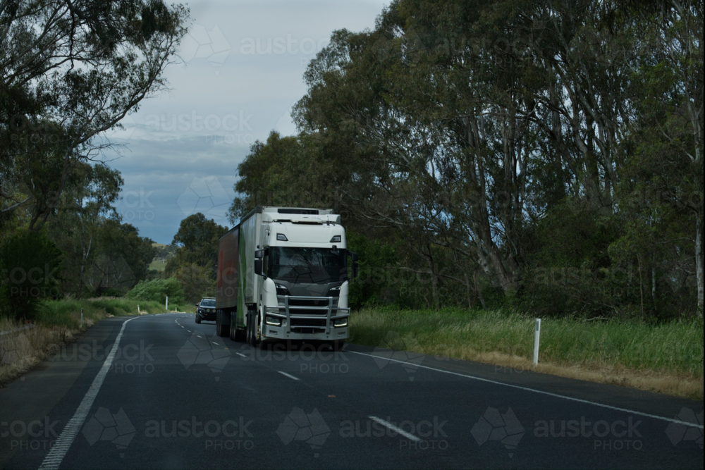 Large B-Double truck with car travelling behind - Australian Stock Image