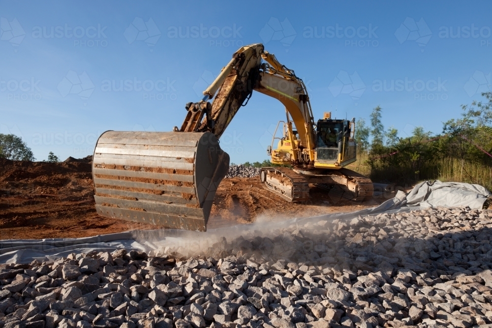 Large digger moving rocks on an industrial building site - Australian Stock Image