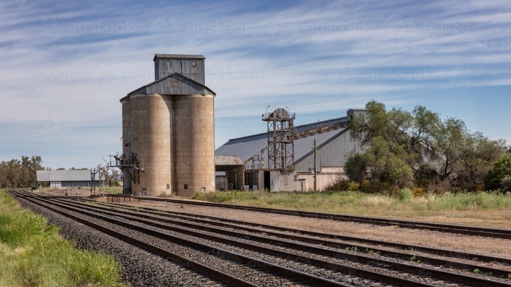 Large grain silos with storage sheds & railway lines for grain transportation - Australian Stock Image