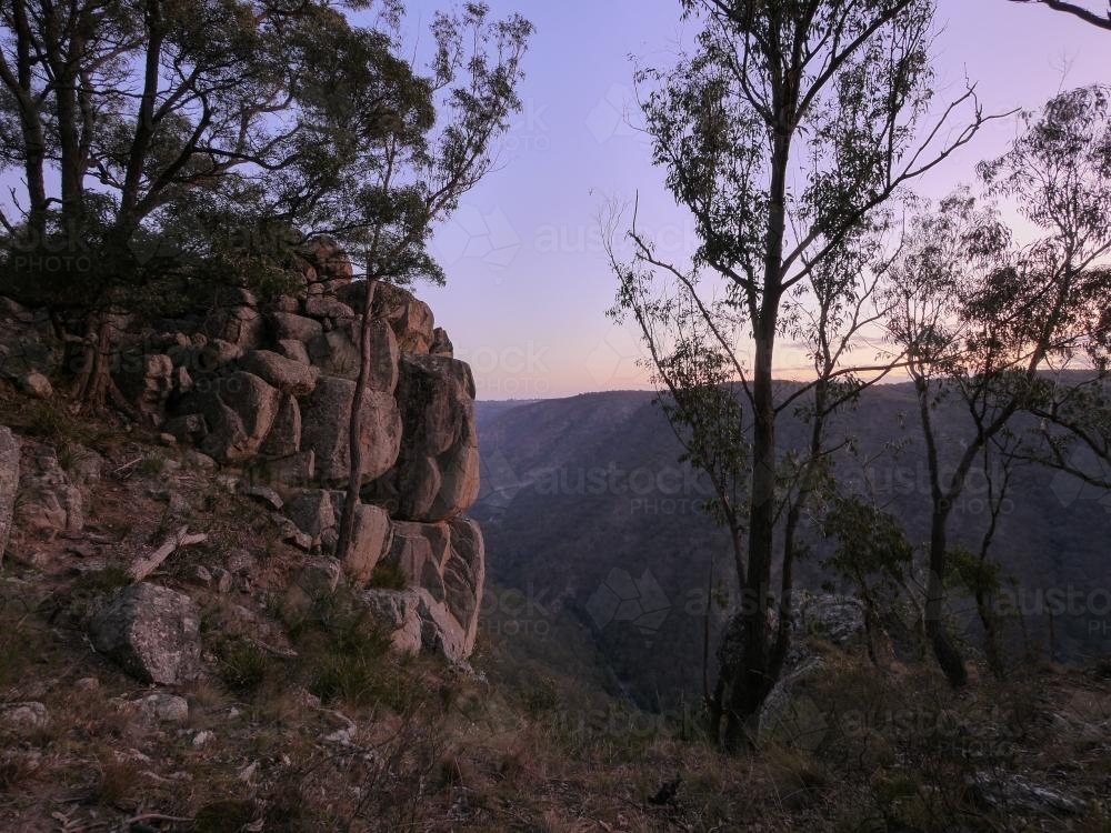 Large granite rockface on the edge of a gorge at dusk - Australian Stock Image