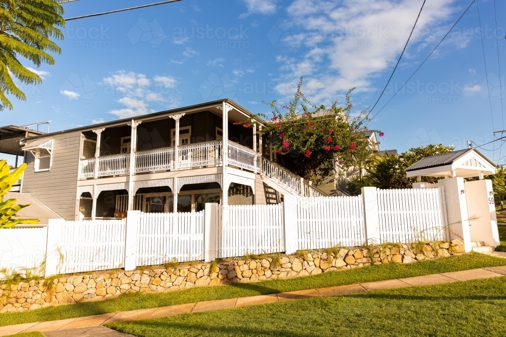 large renovated queenslander house with verandah and white fence - Australian Stock Image