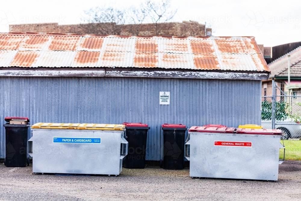 Large skip bins for rubbish and recycling behind business and shed - Australian Stock Image