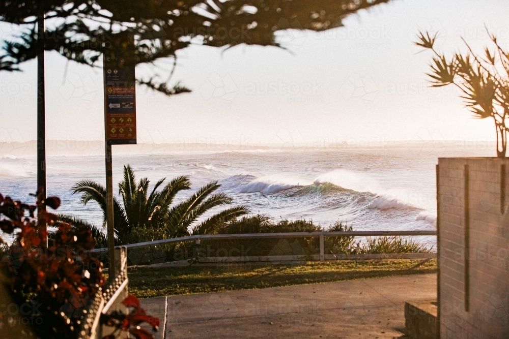 Large swell arriving along coastline at sunrise - Australian Stock Image