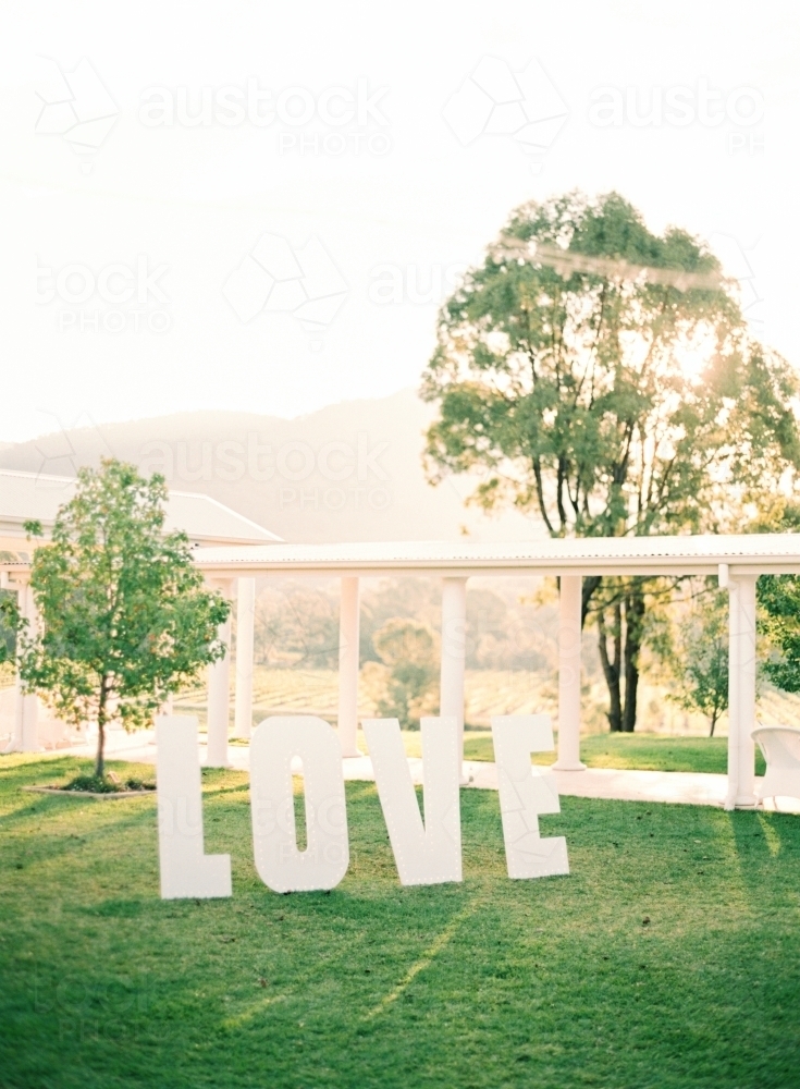 Large white letters spelling LOVE on green grass for a wedding - Australian Stock Image