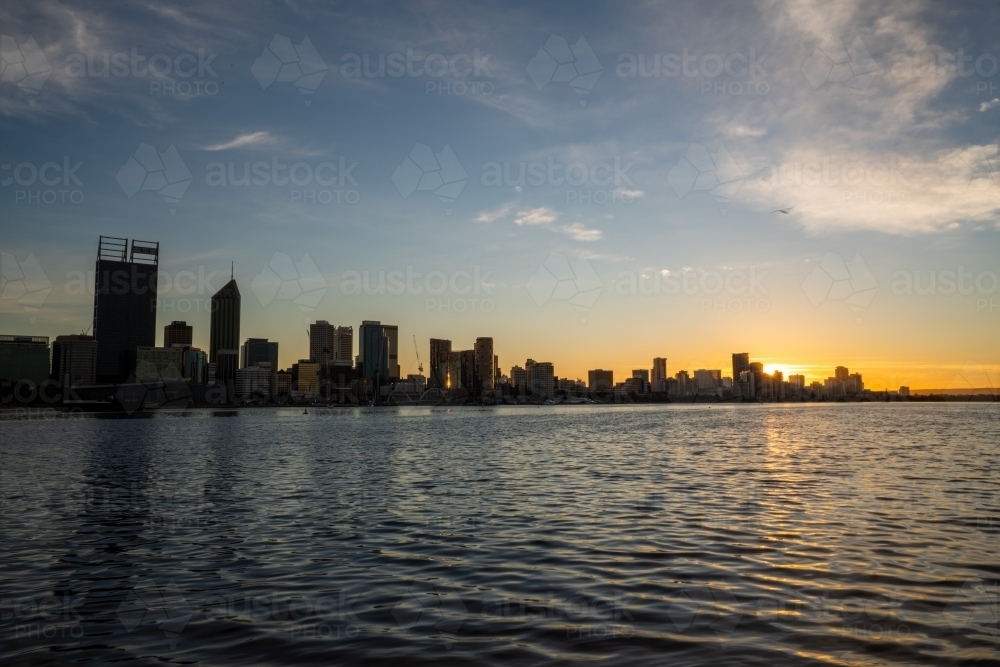 Last light setting behind Swan River and Perth city skyline - Australian Stock Image