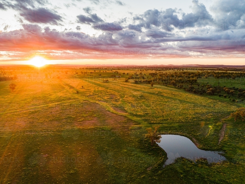 Last rays of sunlight over farmland and dam - Australian Stock Image