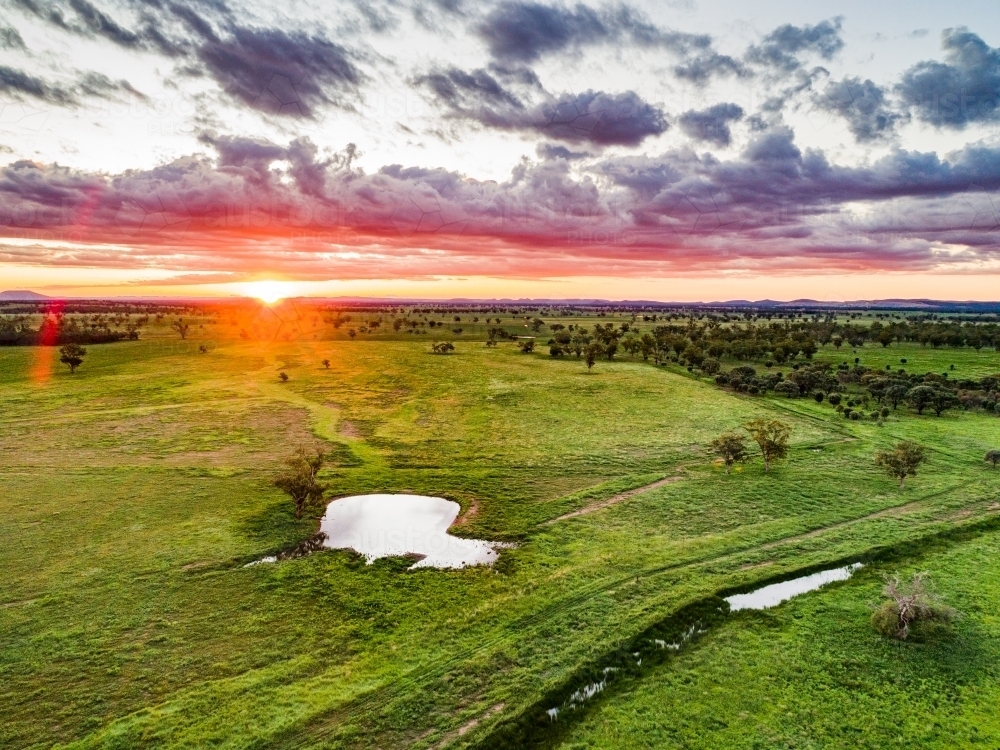 Last rays of sunlight over farmland and dam - Australian Stock Image