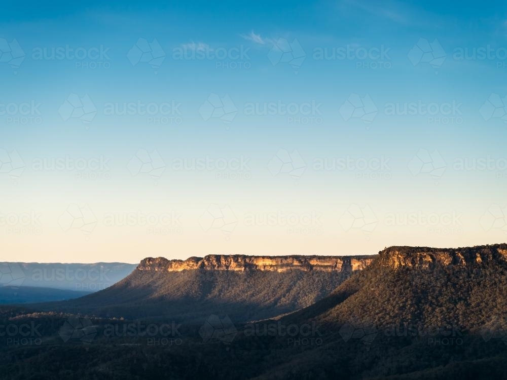 Last sun on hills of sandstone mesa formations in Cattai National Park - Australian Stock Image